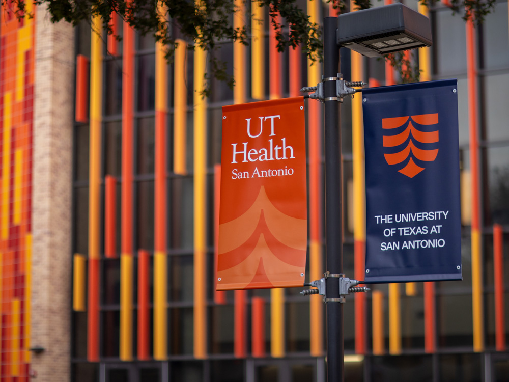 A photo of a banner illustrating the merger between UT San Antonio and UT Health.